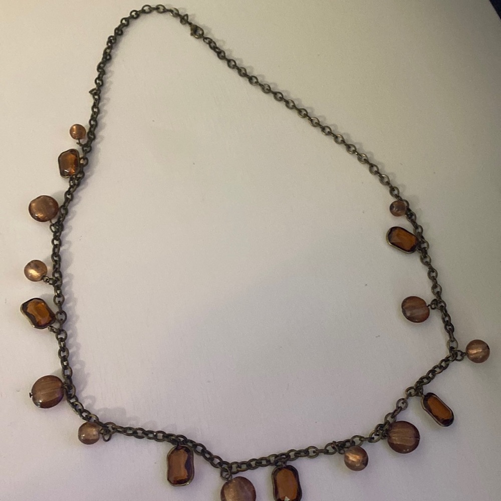 Boutique gold chain necklace with beads and gems on it